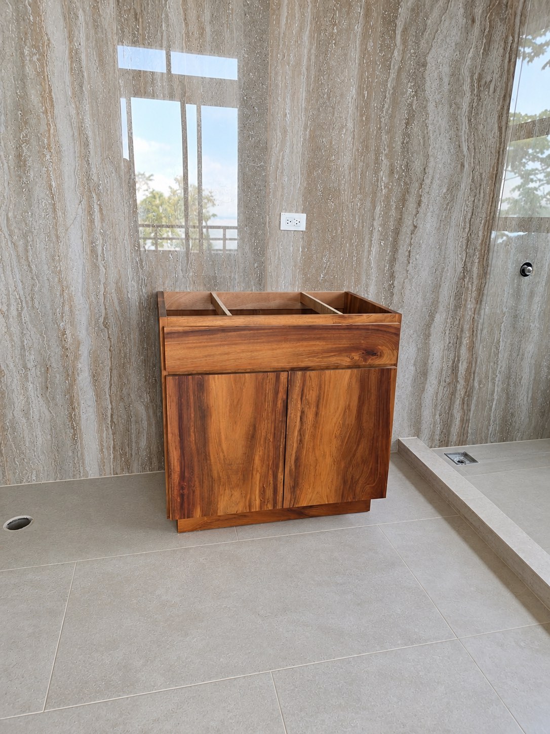 Mueble de baño en madera frente a pared de mármol